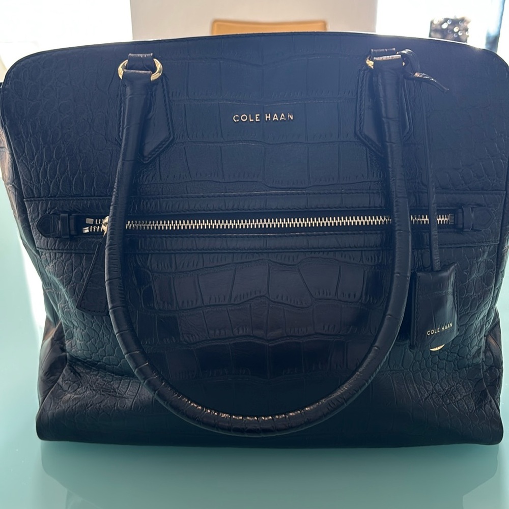 Cole Haan back leather shoulder strap handle. Snap closure. Zipper compartment.